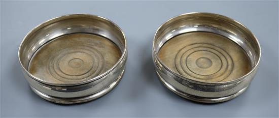 A pair of 1960s silver wine coasters with turned wooden bases, London, 1968/9, 13.2cm.